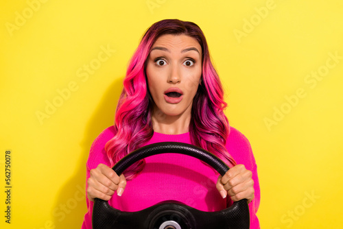 Portrait of impressed confused lady open mouth arms hold wheel isolated on yellow color background