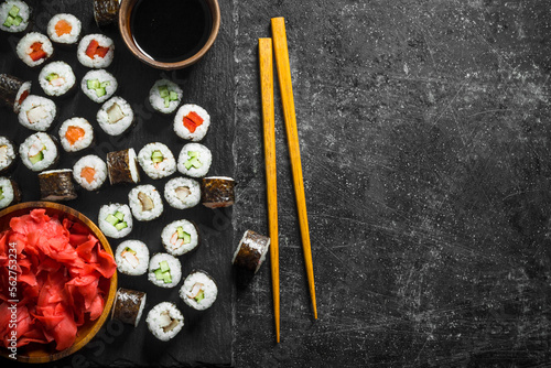 Sushi rolls on a stone Board with soy sauce and ginger.