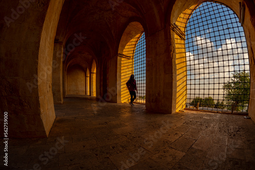 Inside viev of Kasimiye Madrasah of Mardin Province, beautiful stone architecture religion school with colorful sunset light and fences and people photo
