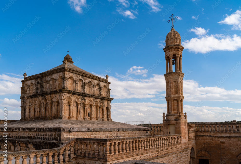 Viev of Anitli virgin mary Monastery of Mardin Province, beautiful stone architecture tower with cross stairs wall and door with blue sky with clouds