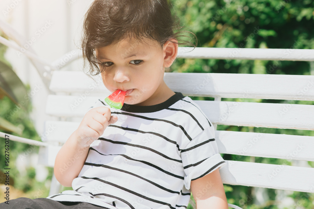 cute latin indian kid child eating sweet fruit ice cream sitting
