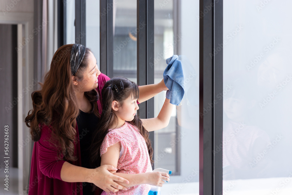 happy girl daughter with mom mother clean and wash window glass together as good teamwork for housekeeping activity during weekend at home happy girl daughter with mom mother clean and wash window glass together as good teamwork for housekeeping activity during weekend at home