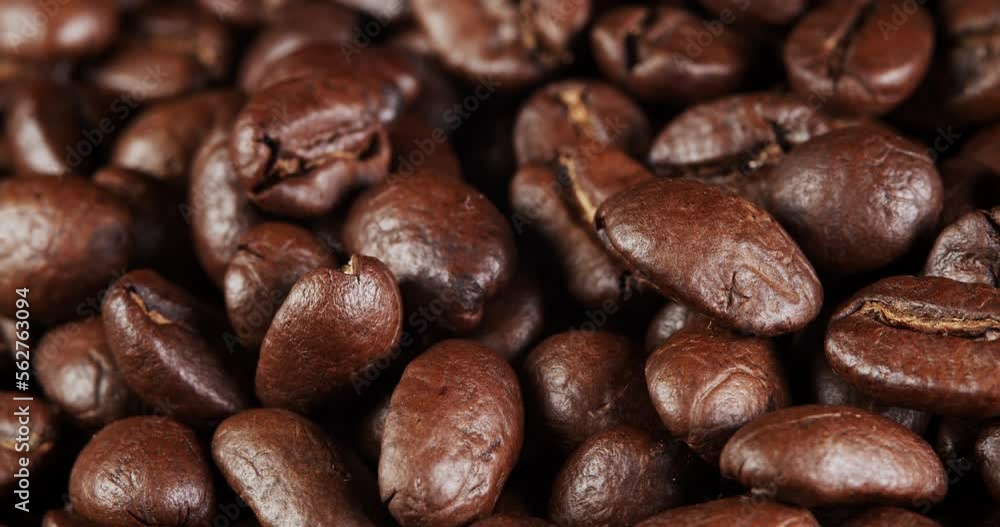 Roasted coffee beans dolly shot. Aromatic coffee beans move slowly. Slide slow motion close-up of whole roasted coffee beans. Roasted coffee beans dolly shot. Aromatic coffee beans move slowly. Slide slow motion close-up of whole roasted coffee beans.