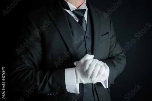 Portrait of Butler in Dark Suit and White Gloves Eager to be of Service. Concept of Service Industry and Professional Hospitality.