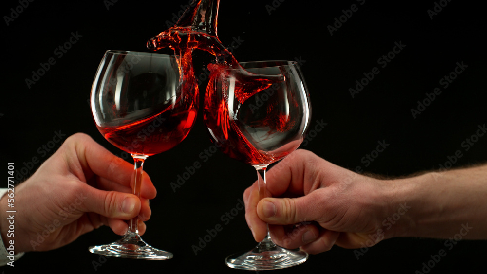 Two men clinking with glasses of red wine, celebrating success. Two men clinking with glasses of red wine, celebrating success.