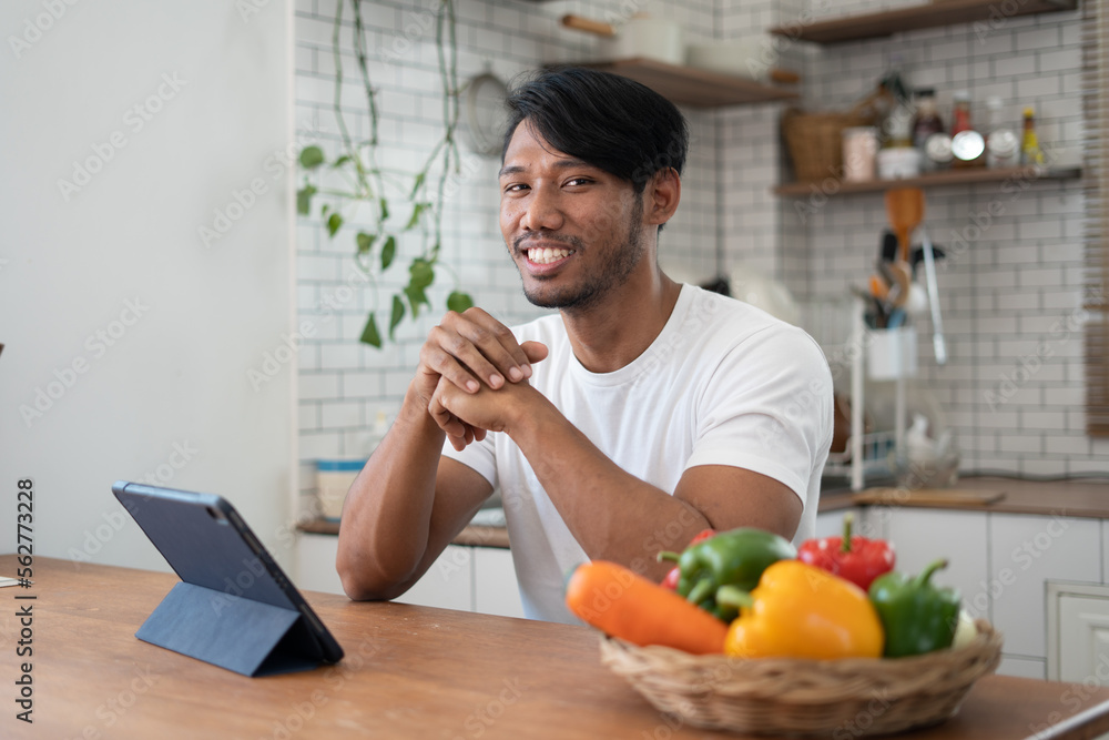 Handsome asian man cooking at home preparing salad in kitchen. Handsome asian man cooking at home preparing salad in kitchen.