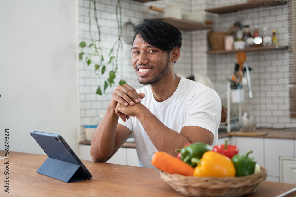 Handsome asian man cooking at home preparing salad in kitchen. Handsome asian man cooking at home preparing salad in kitchen.