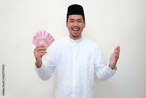 Moslem Asian man showing happy expression while holding money photo