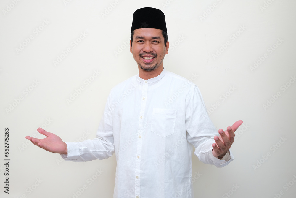 Moslem Asian man smiling with arms open when doing greeting pose Moslem Asian man smiling with arms open when doing greeting pose