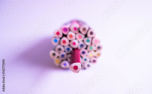 Red pencil standing out from others. Colorful wooden pencils on white background