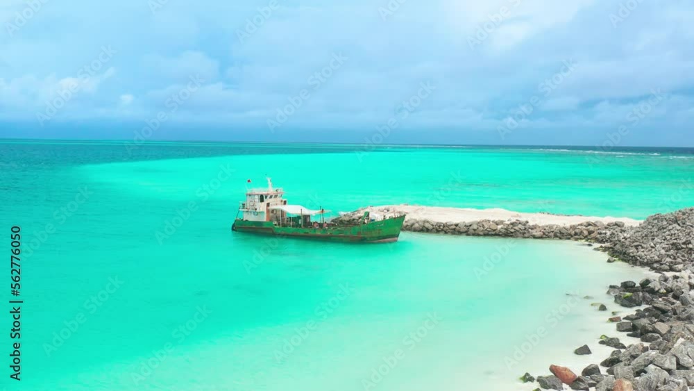 Old rusty ship in turquoise water of Fulidhoo island in the Maldives. Aerial top view. Old rusty ship in turquoise water of Fulidhoo island in the Maldives. Aerial top view.