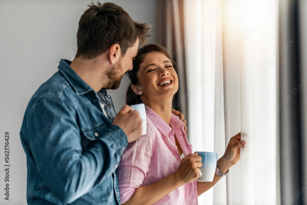 Couple in love in new home ,drinking coffee near window Couple in love in new home ,drinking coffee near window