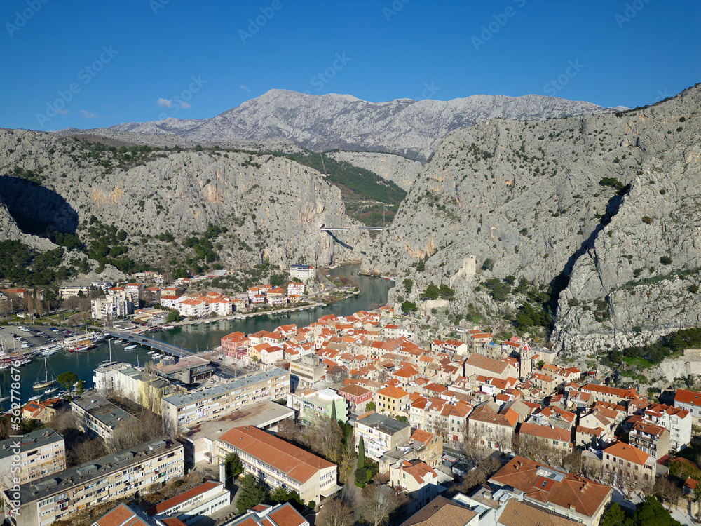Aerial drone view of Omis town in Croatia. Location is where the Cetina River meets the Adriatic Sea.  Beautiful city next to the mountains and the sea. Travel and holidays destination.