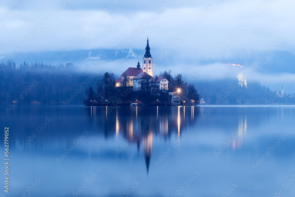 Sunrise winter scenery of magical Lake Bled in Slovenia. A winter tale for romantic experiences. Mountains with snow in the background. Church of the Mother of God on a little Island in the lake.