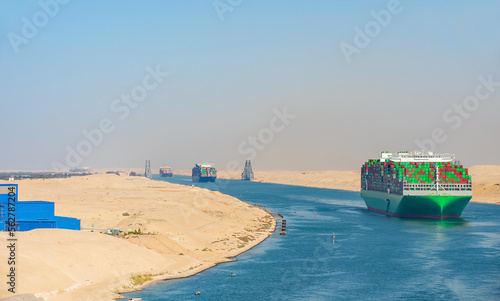 Cuadro en lienzo Large container ship, accompanied by tugboat, passing through the Suez Canal in Egypt
