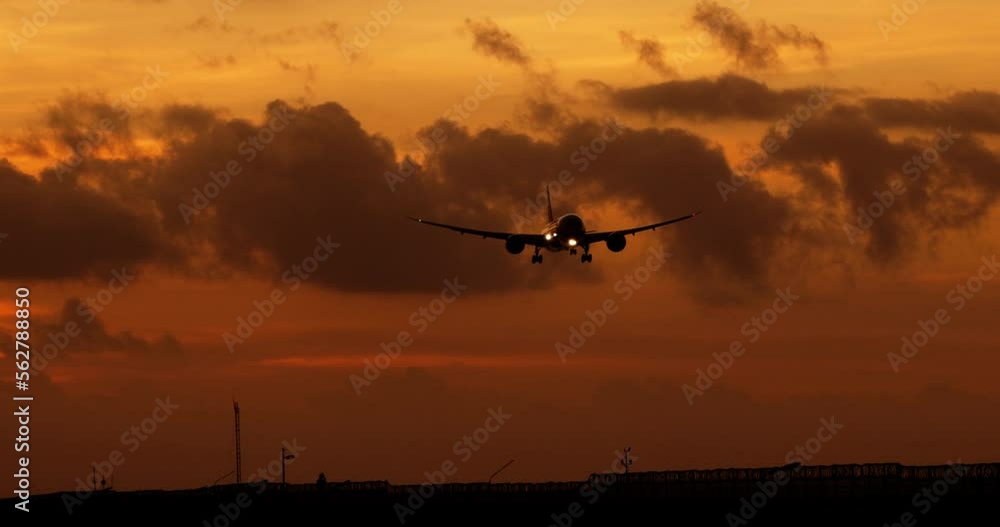 Silhouette of airplane lowers altitude and speed in preparation for landing on airport runway. Silhouette of passenger plane in orange sky. Long-awaited opening of borders after epidemic of covid-19 Silhouette of airplane lowers altitude and speed in preparation for landing on airport runway. Silhouette of passenger plane in orange sky. Long-awaited opening of borders after epidemic of covid-19