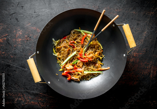 Fragrant Chinese cellophane noodles in a frying pan wok with salmon and vegetables.
