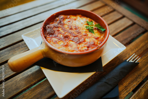 Freshly baked lasagna in a round pot photo