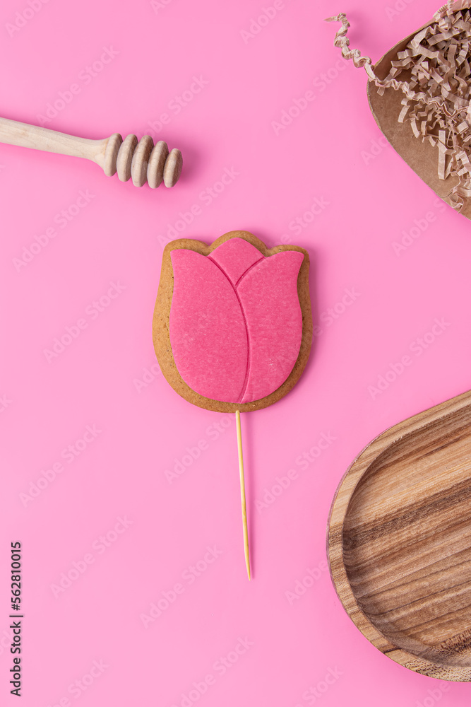 Spring gingerbread with icing on pink background. Gingerbread in the form of a tulip. Vertical