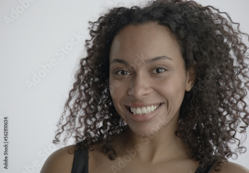 CU Headshot portrait of beautiful 20s African-American Black female posing against white background, no make-up, clean skin. Shot with ARRI Alexa Mini LF