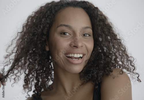 CU Headshot portrait of beautiful 20s African-American Black female posing against white background, no make-up, clean skin. Shot with ARRI Alexa Mini LF