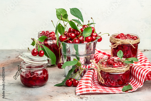 cherry jam in a jar and fresh berries on the table. Preserved organic food from garden on a light background. banner, menu, recipe place for text