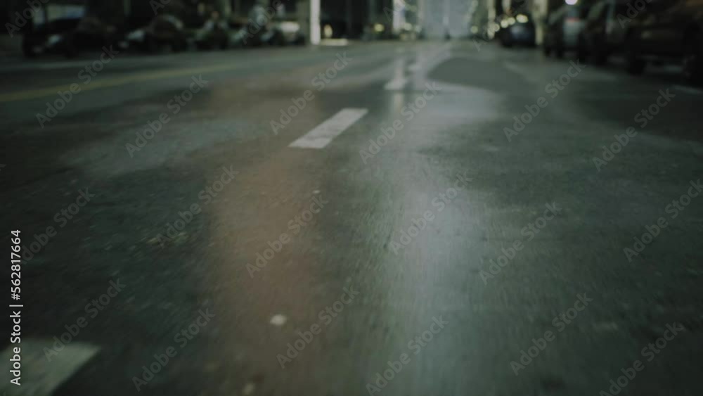 close-up cinematic POV shot of wet asphalt in the morning after rain on street road. Cars and people silhouettes out of focus in the background of city close-up cinematic POV shot of wet asphalt in the morning after rain on street road. Cars and people silhouettes out of focus in the background of city