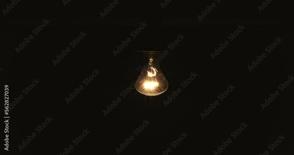 Lamp with tungsten bulb assembly slowly turn on and off on black background Lamp with tungsten bulb assembly slowly turn on and off on black background