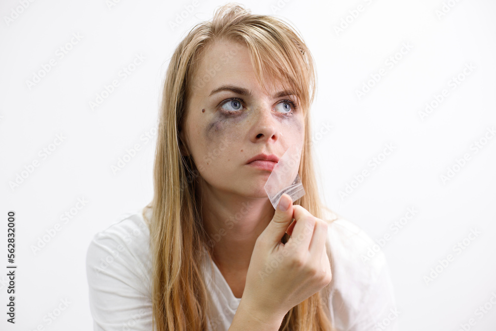 portrait of a woman tearing tape from her mouth portrait of a woman tearing tape from her mouth