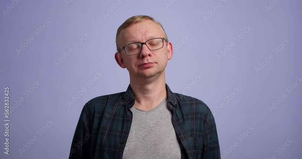Man gives tired emotion with yawn against blue background, studio shot Man gives tired emotion with yawn against blue background, studio shot