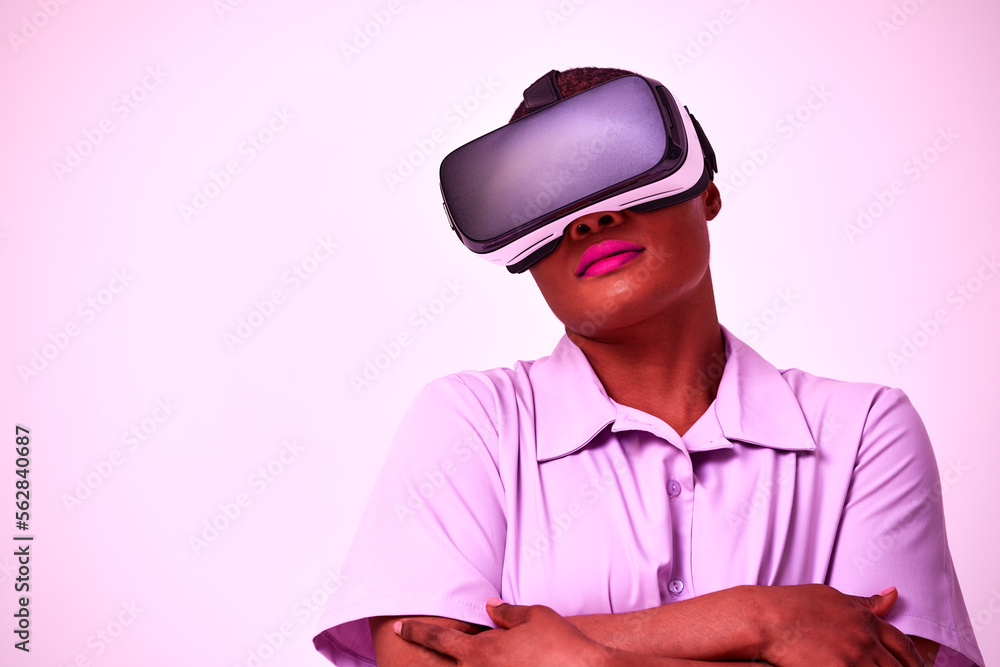 Young african american positive woman in black virtual reality glasses with vr headset posing, looking, playing and touching hands on purple background. Young african american positive woman in black virtual reality glasses with vr headset posing, looking, playing and touching hands on purple background.