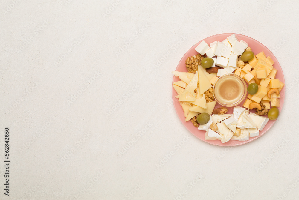 Cheese plate with olives aand nuts on concrete background, top view