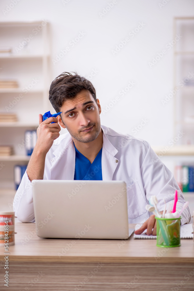 Young male dentist working in the clinic