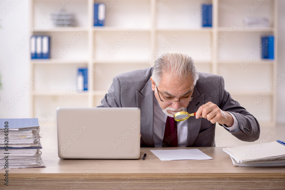 Old male employee working in the office Old male employee working in the office