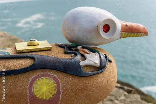 Figurine of seagull with the image of Jacques-Yves Cousteau on the wall of the fortress in Nazare close up photo