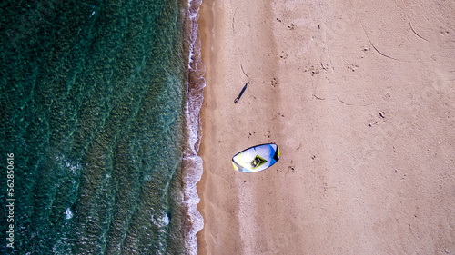 Canvas Print Vertical aerial view shot of a man walking with a twin tip board and a kite, pre