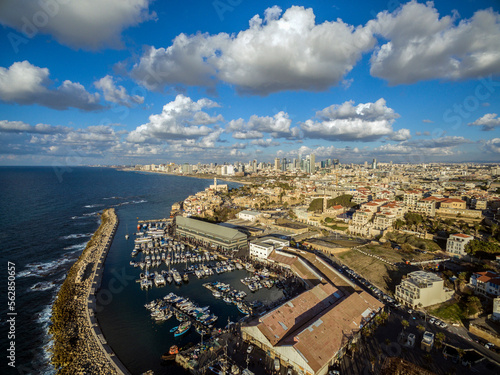 Aerial view of Ships anchoring at the Jaffa port in a cloudy day. tel aviv skyline with urban skyscrapers at the background