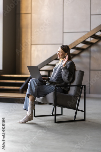 Portrait of womanwaving hand video call laptop sit inchair © F8  \ Suport Ukraine