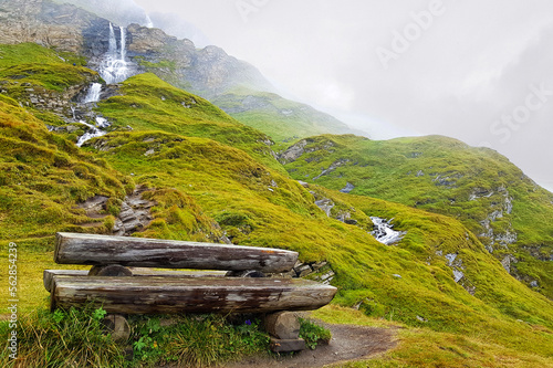A wooden table in front of the Stauseeblick waterfall, at the Grossglockner high Alpine road, Großglockner Hochalpenstraße, in a winter day, Austria