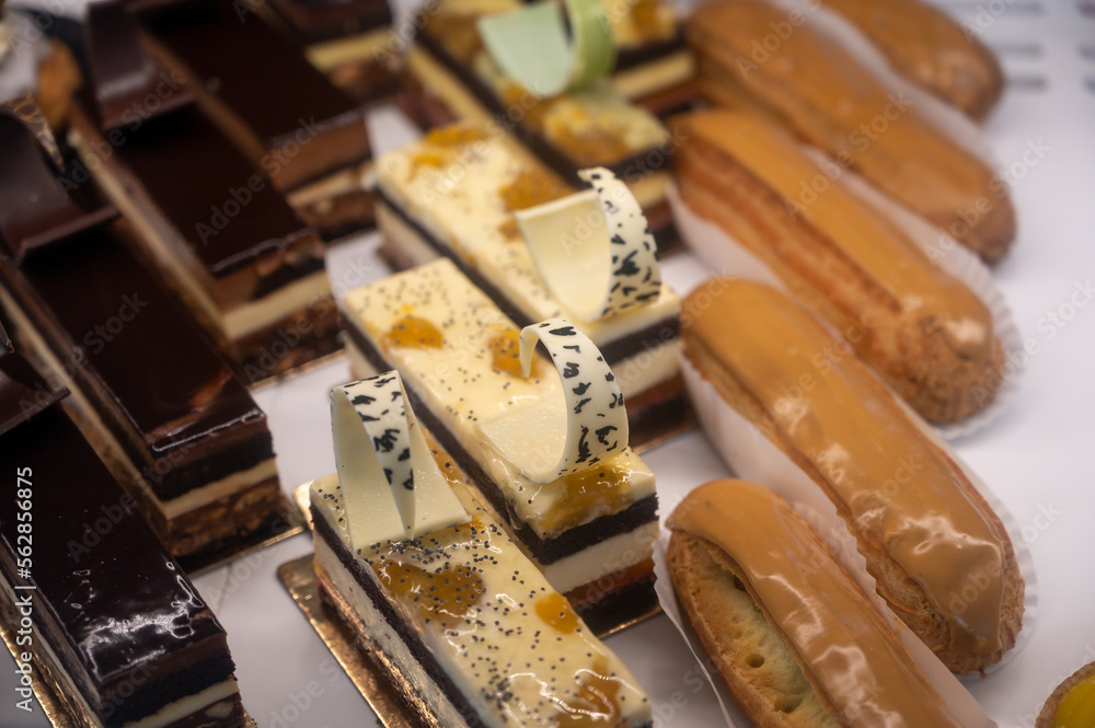 Assortment of french fresh baked sweet pastry with fresh fruits and berries in confectionery shop