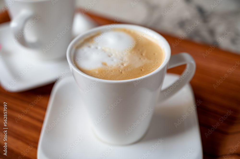 White cup of coffee latte served in outdoor cafe in France White cup of coffee latte served in outdoor cafe in France