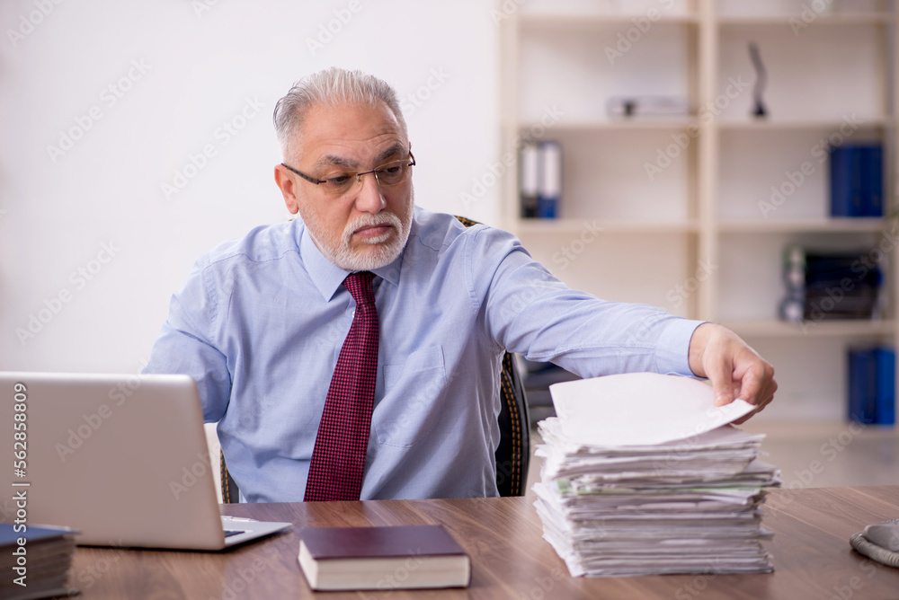 Old male boss working at workplace Old male boss working at workplace
