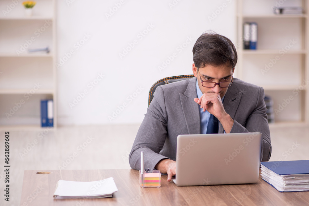 Young male employee working in the office Young male employee working in the office