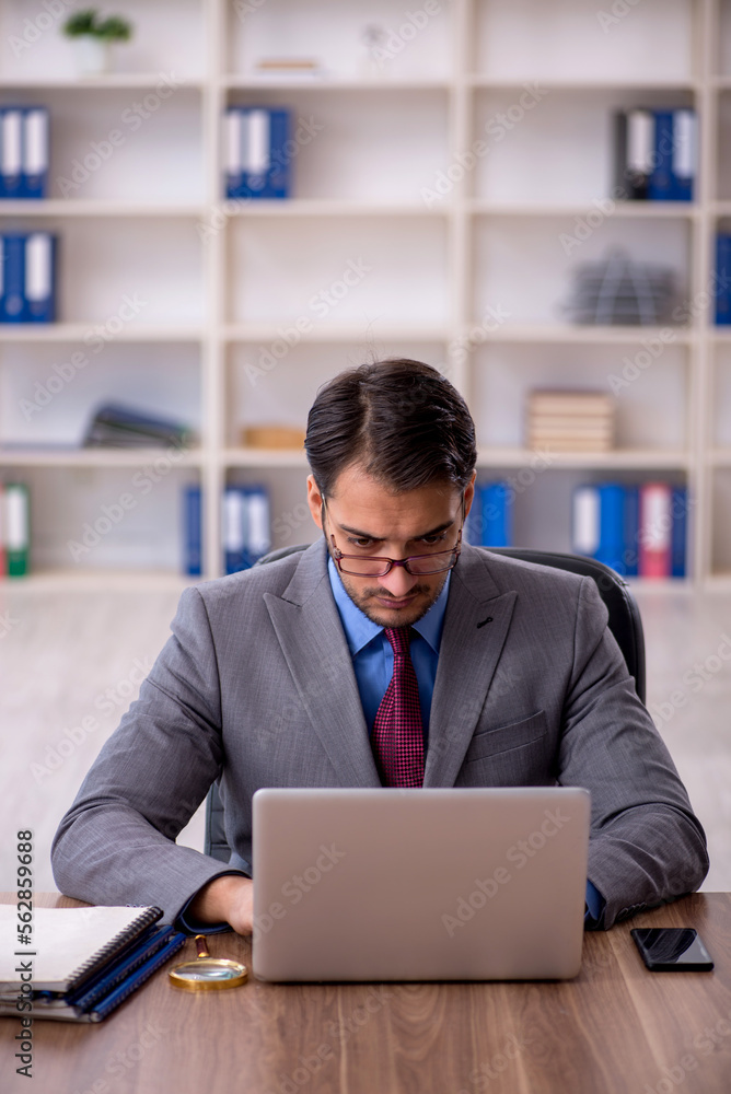 Young male employee working in the office Young male employee working in the office