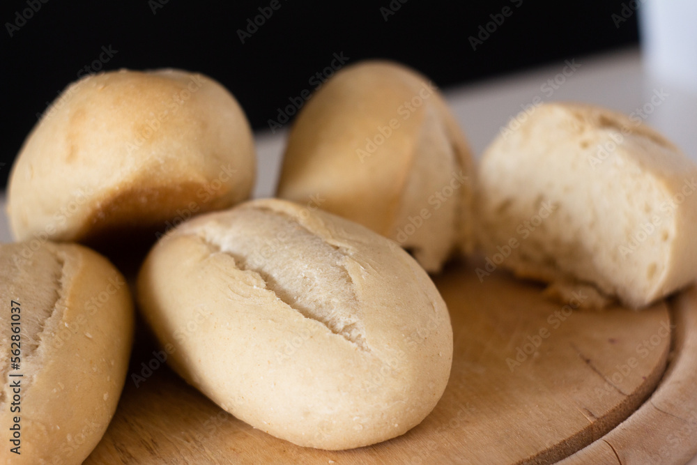 close-up of wheat buns on a wooden cutting board on a dark background