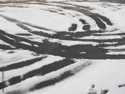 車の走った跡が残る雪の積もった道路