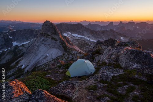 A tent with a picturesque sunset view of the mountains.