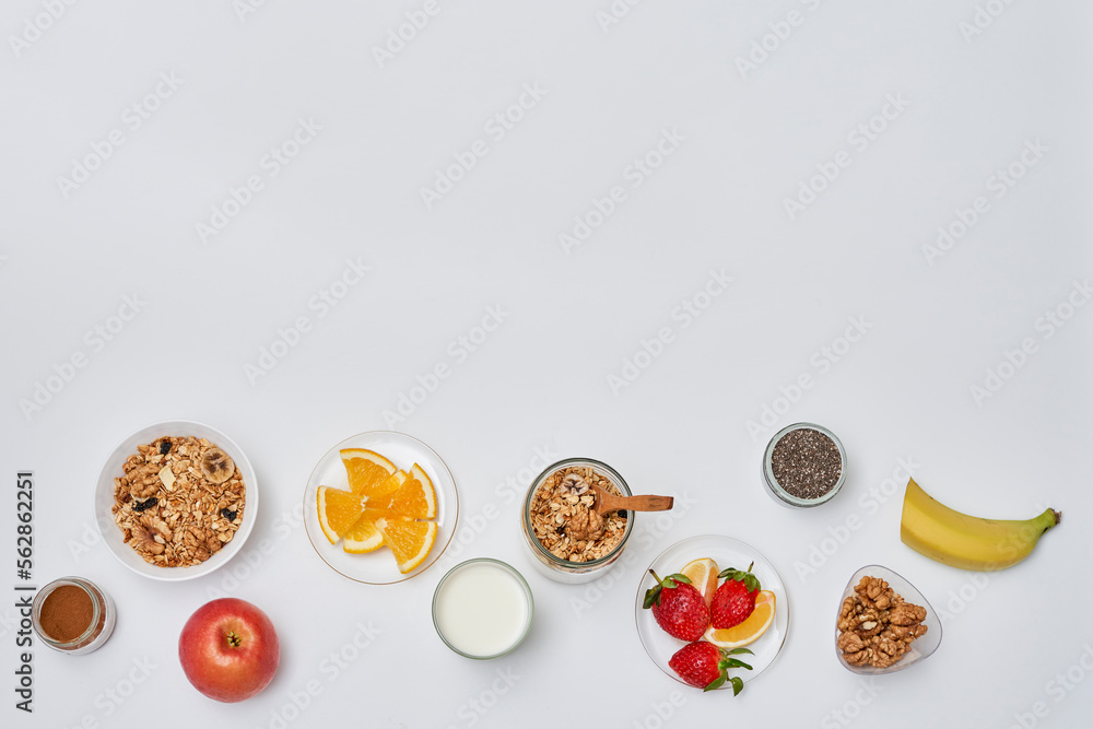 some fruit and yories on a white surface with an apple, banana, strawberries, oats, granos, milk some fruit and yories on a white surface with an apple, banana, strawberries, oats, granos, milk
