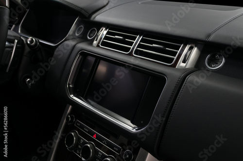 Car interior detail. Panel with multimedia screen, control buttons and air conditioner holes.
