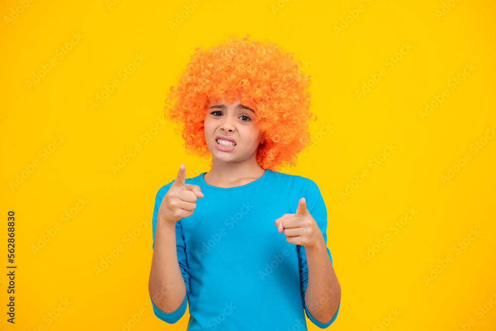 Girls birthday party. Funny kid in curly redhead wig. Time to have fun. Teen girl with orange hair, being a clown. Angry face, upset emotions of teenager girl. Girls birthday party. Funny kid in curly redhead wig. Time to have fun. Teen girl with orange hair, being a clown. Angry face, upset emotions of teenager girl.
